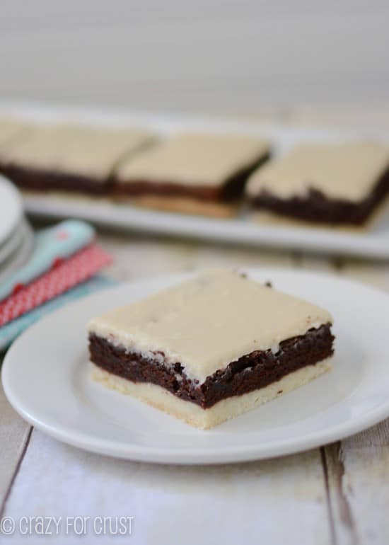 brownies with a crust and mocha frosting on white plate