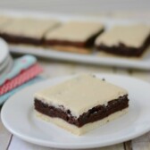 brownies with a crust and mocha frosting on white plate