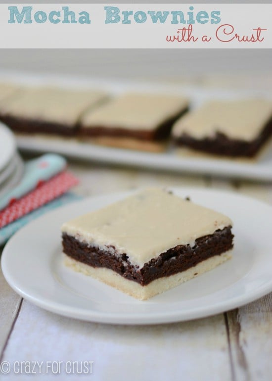 brownies with a crust and mocha frosting on white plate