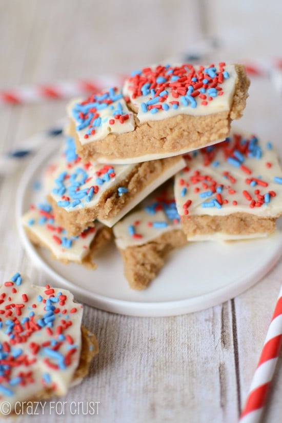Stack of Patriotic Peanut Butter Cookie Dough Bark on a white plate with patriotic straws around it