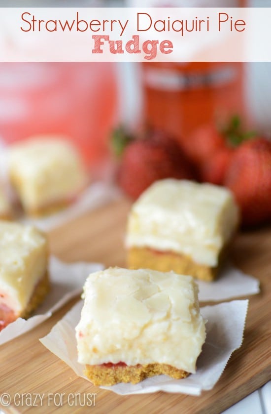 slice of fudge that has a crust on parchment paper on cutting board with drink behind