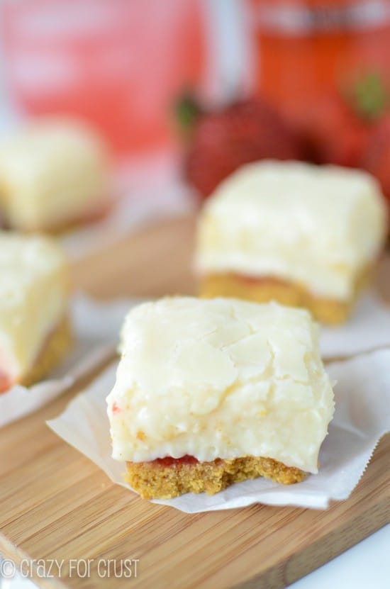 Close up shot of Strawberry Daiquiri Pie Fudge pieces on parchment paper on wood cutting board