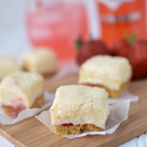 slice of fudge that has a crust on parchment paper on cutting board with drink behind