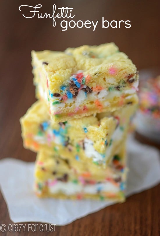 funfetti gooey bars stack on parchment paper with title