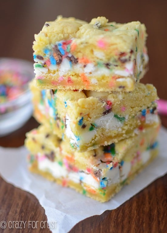 Stack of funfetti gooey bars on parchment paper