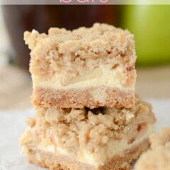 stack of bars with crust, apple cheesecake and crumble topping on parchment