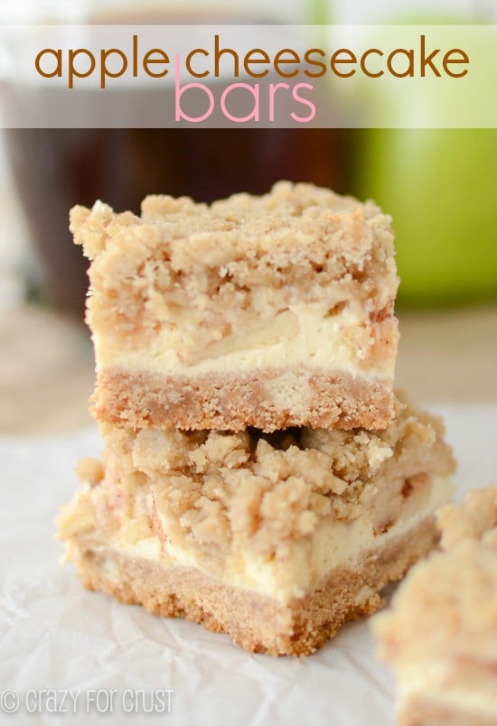 apple cheesecake bars stacked up on a parchment paper