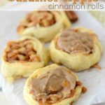 caramel apple cinnamon rolls with caramel frosting on parchment