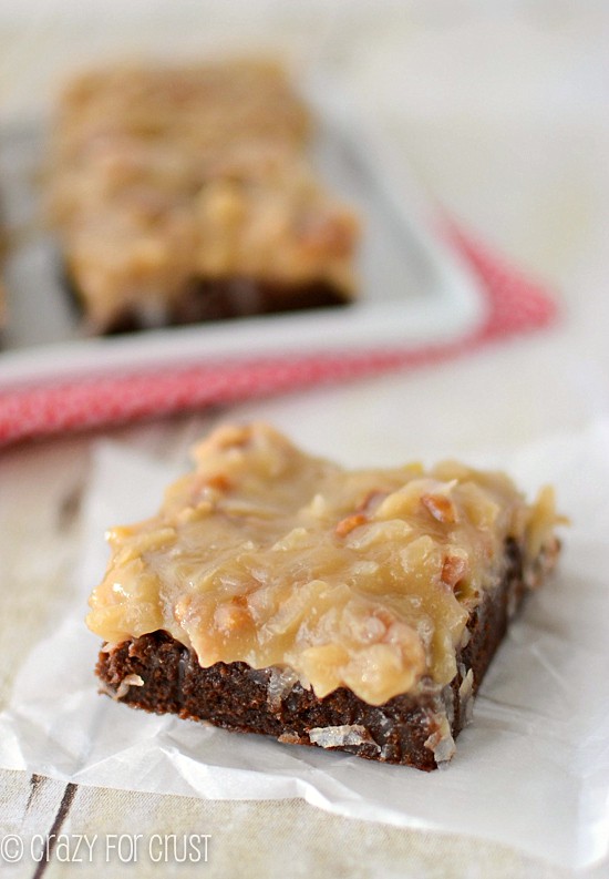 german chocolate brownie with coconut pecan frosting on parchment paper
