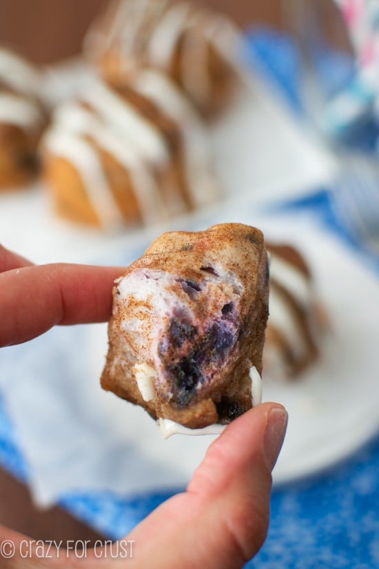 Bite of Blueberry Monkey Bread Muffin being held close up to the camera