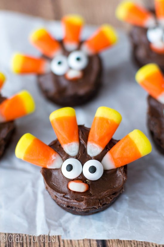 Overhead shot of Brownie Turkeys made with Candy Corn on white parchment paper on wood table