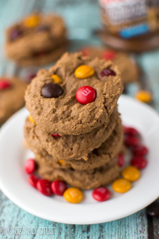 Stack of four Easy Dark Chocolate Peanut Butter Cookies on a white plate with m&ms