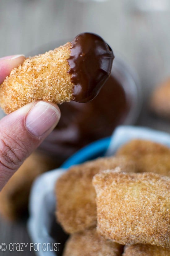 One bite of Easy Cinnamon Sugar Soft Pretzel Bites with chocolate dipping sauce on end