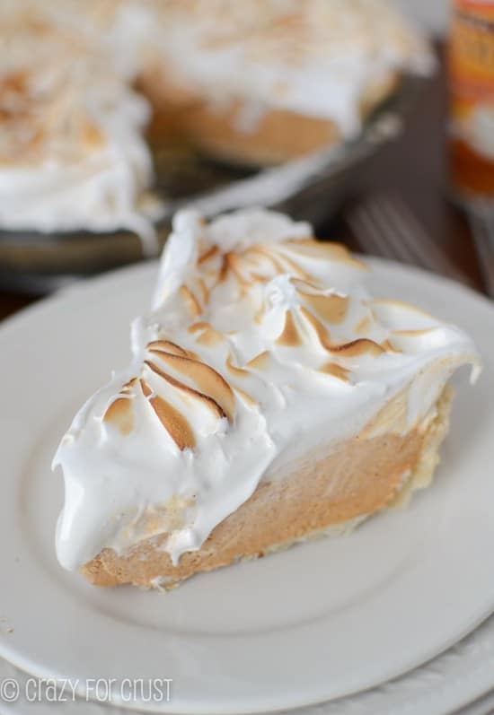 Close up shot of a slice of Frozen Pumpkin Meringue Pie on stacked white plates