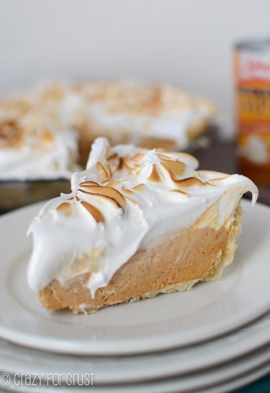 Close up shot of a slice of Frozen Pumpkin Meringue Pie on four stacked white plates