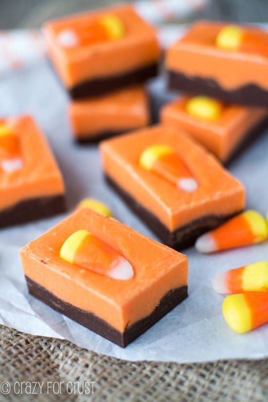 Pieces of Halloween Fudge with candy corn on white parchment paper on burlap