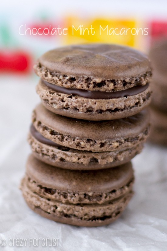 Three stacked Chocolate Mint Macarons on white parchment paper