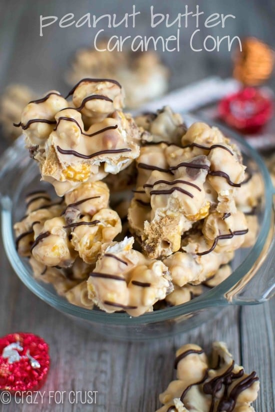 caramel corn coated with peanut butter white chocolate in clear dish with candy around