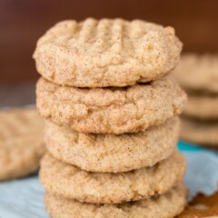 Stack of Peanut Butter Snickerdoodles on parchment paper with title