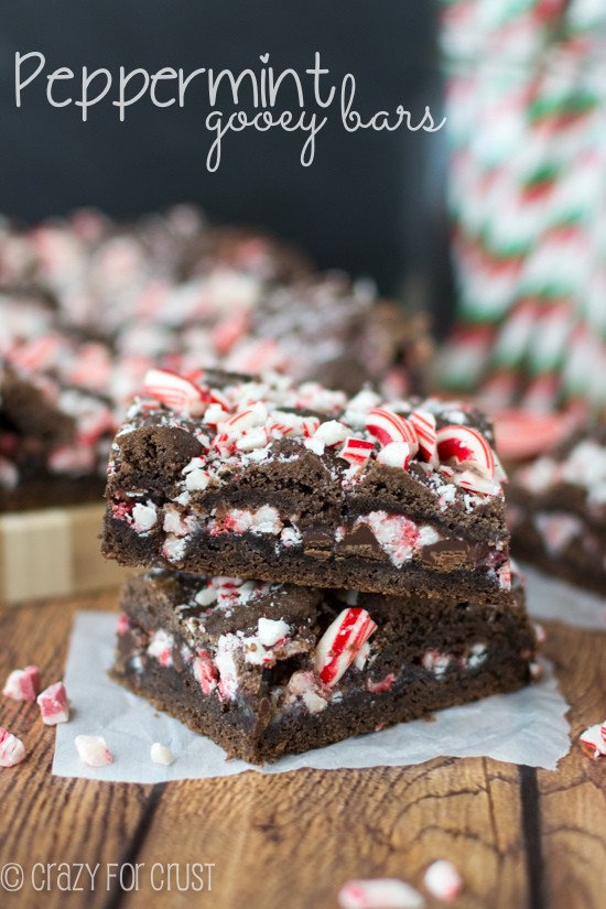 Side view showing two Peppermint Gooey Bars stacked with candy cane pieces inside and on top with recipe title in top left hand corner