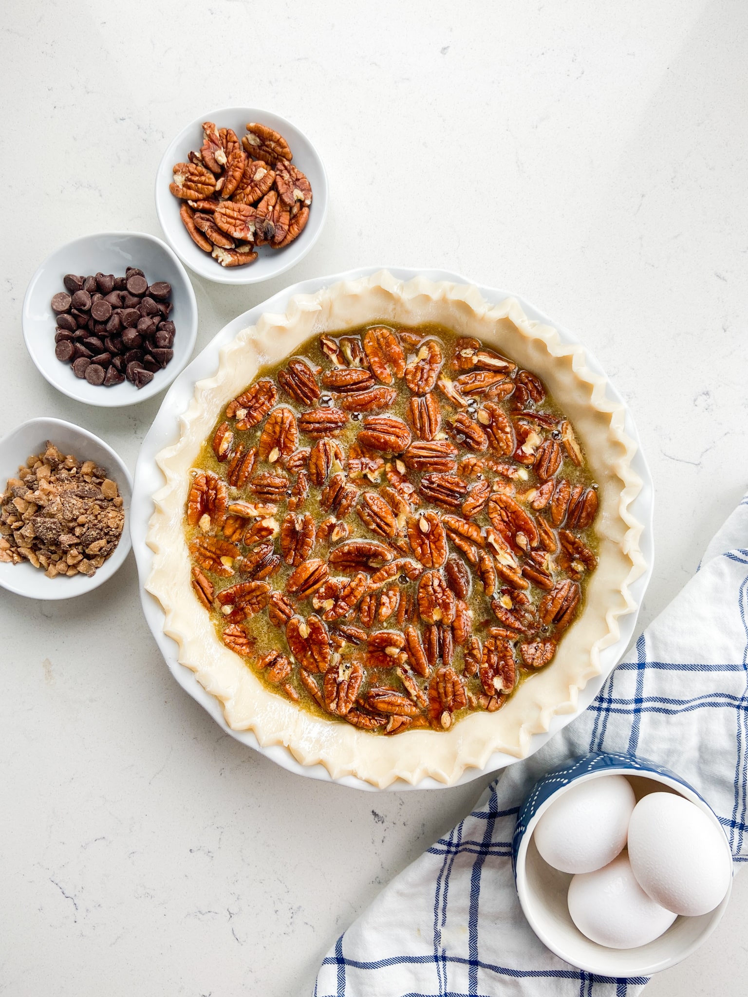 pie shell with pecan pie filling and ingredients around
