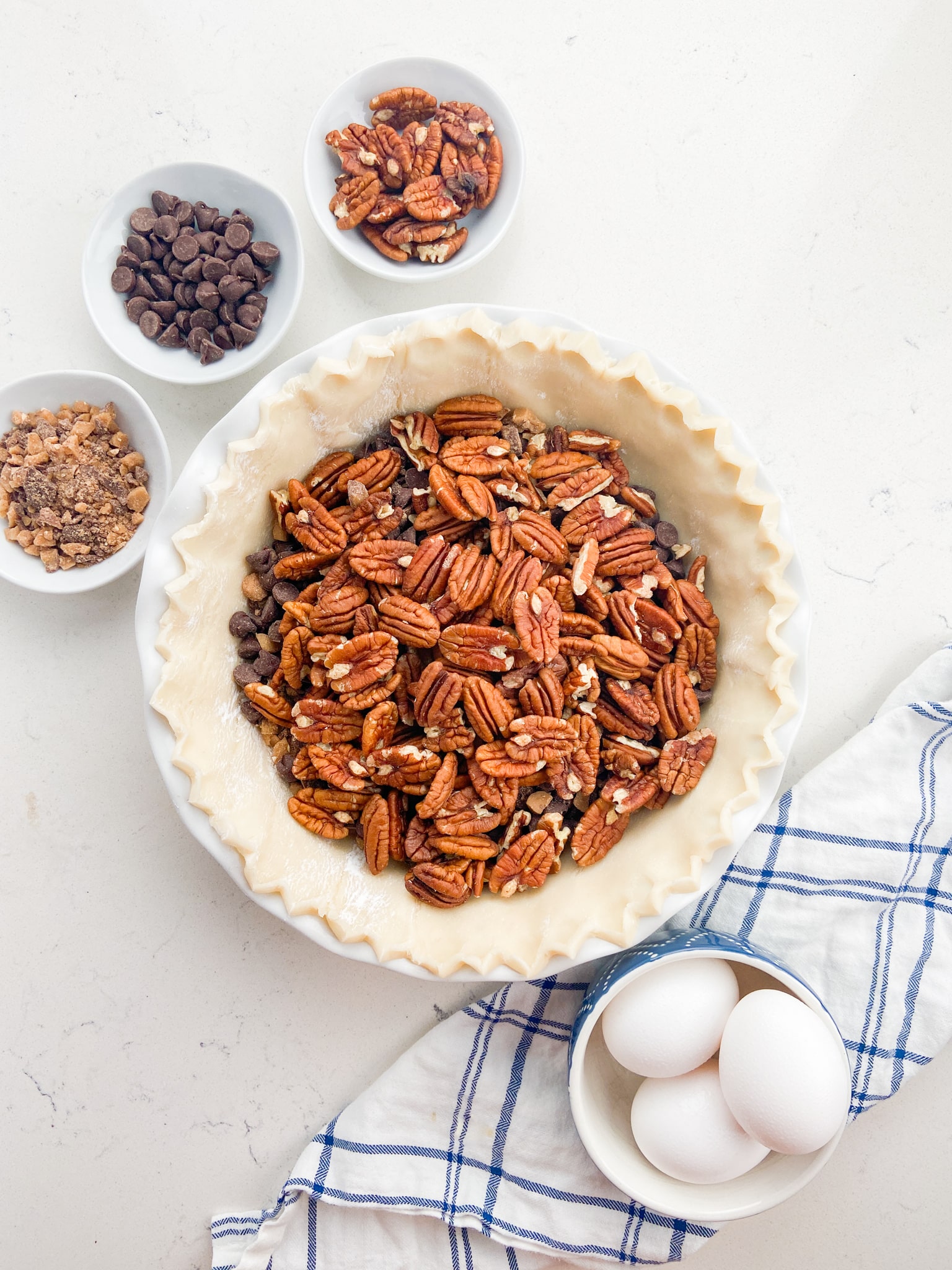 pie shell with pecans and chocolate chips inside