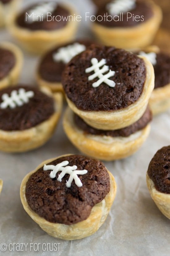 Mini brownie football pies on parchment paper with title