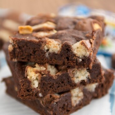 Stack of one bowl candy bar brownies on parchment paper with title