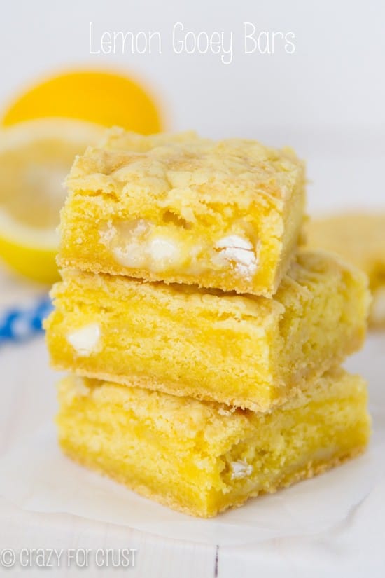 Lemon gooey bar stack on parchment paper with title