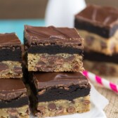 chocolate chip cookie bars with oreo truffles on top and chocolate on white plate