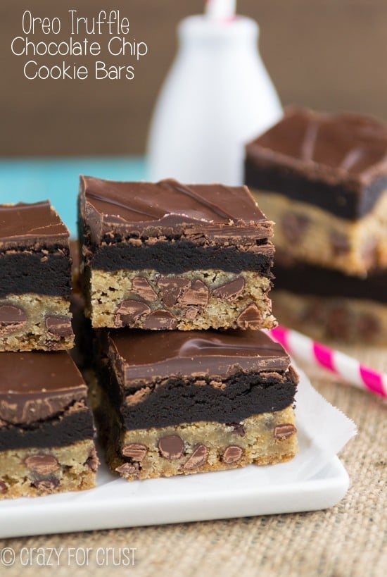 chocolate chip cookie bars with oreo truffles on top and chocolate on white plate