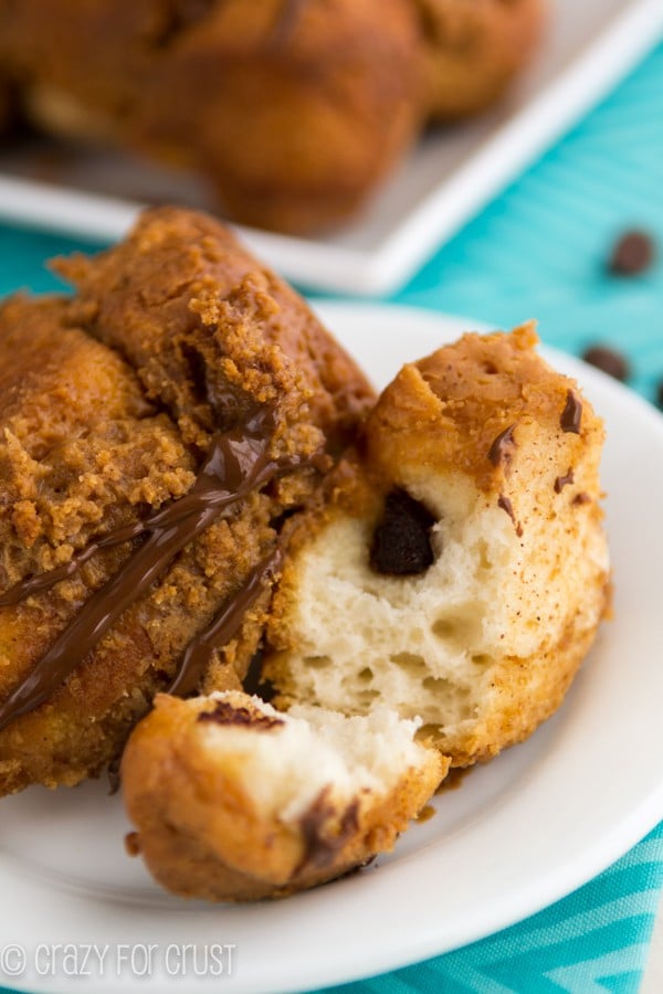 Piece of {Chocolate Stuffed} Peanut Butter Monkey Bread Loaf on a white plate with turqoise napkin underneath