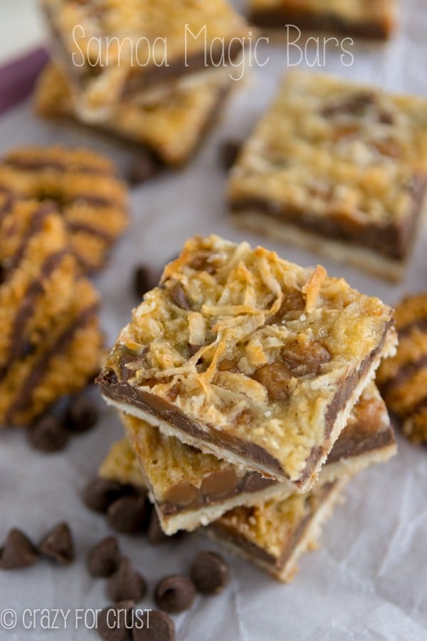 magic cookie bars in a stack with chocolate center and coconut caramel top