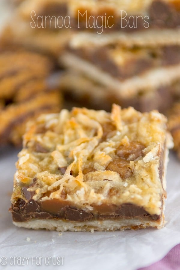 Closeup shot of a Samoa Magic Bar on white parchment paper with more behind it