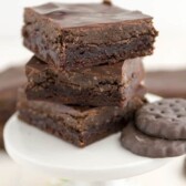 brownies with thin mint truffle topping on white stand in a stack