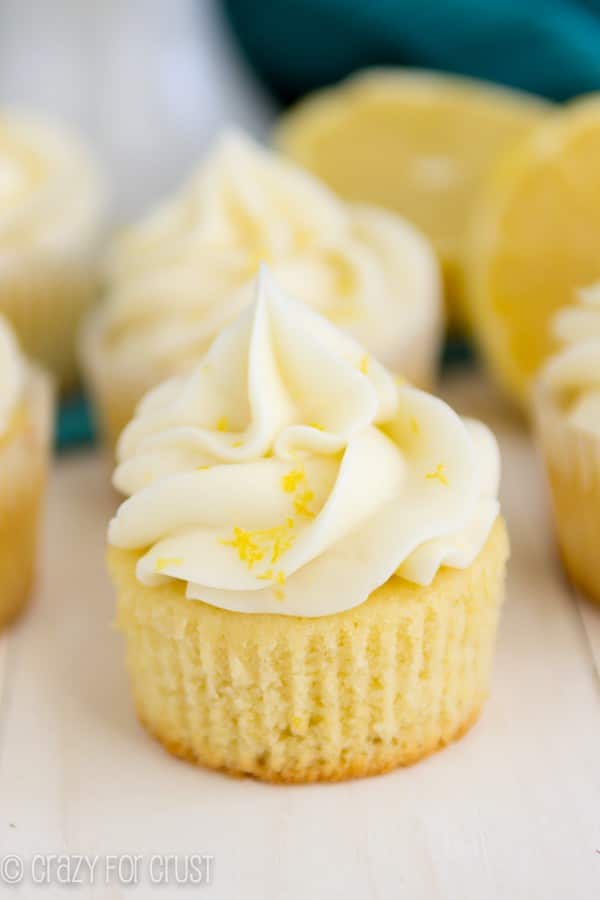 Lemon Cupcakes on a white board with lemons in the background 