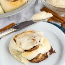 cinnamon roll on white plate with knife