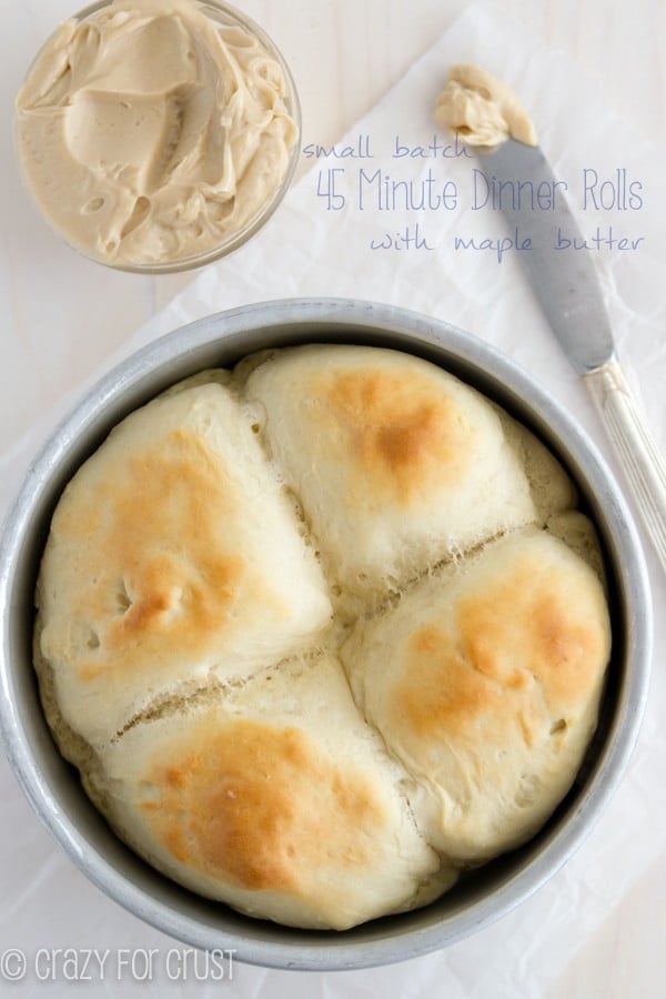Small Batch Dinner Rolls in a round pan with a bowl of butter and butter on a knife with writing