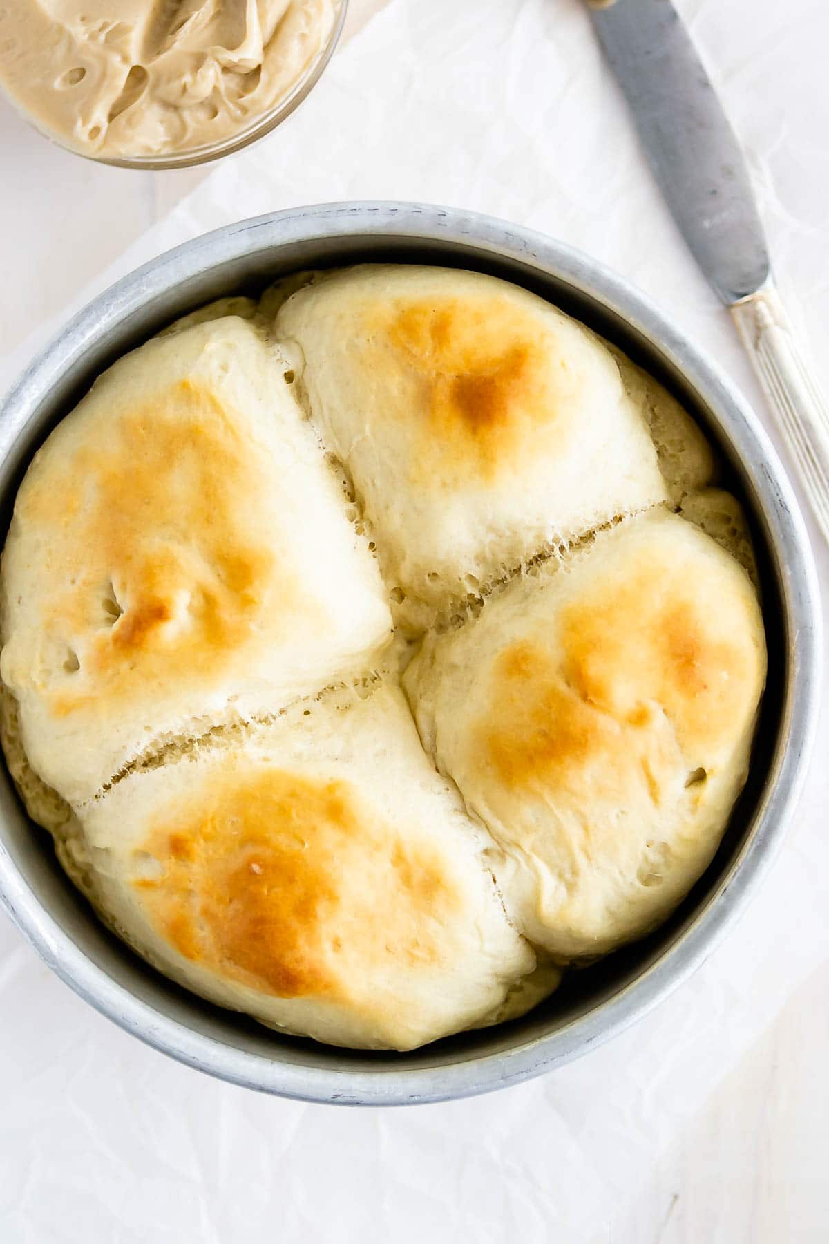 overhead shot of 4 dinner rolls in small cake pan