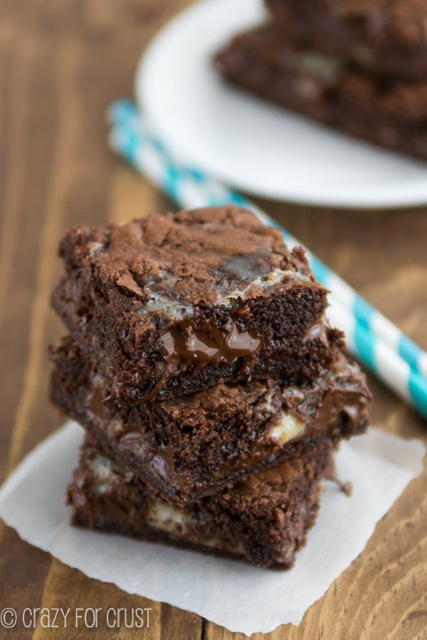 Brownie Gooey Bars on wooden board with teal straws in the background 