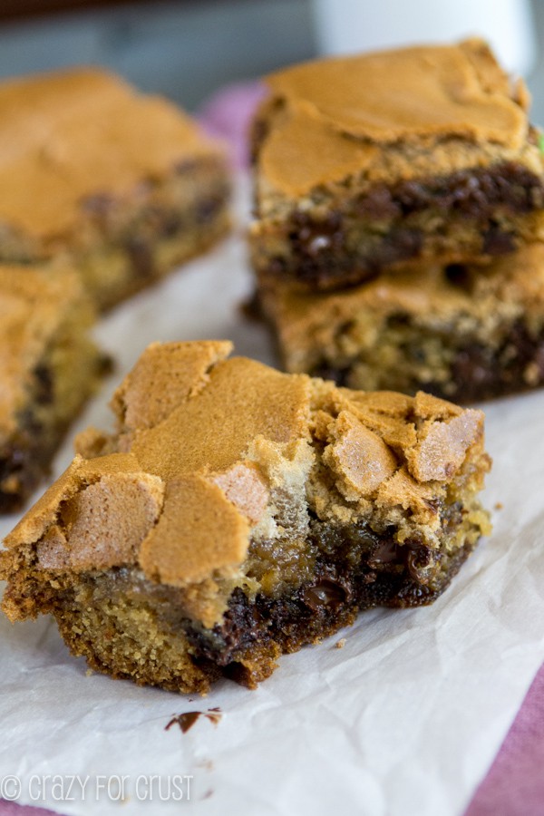 Chocolate Chip Cookie Mud Hen Bars - melty chocolate chip cookie topped with a brown sugar meringue with a bite taken out of one