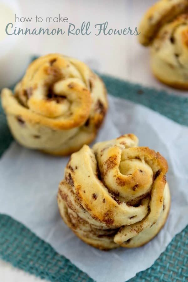 Cinnamon Roll Flowers sitting on parchment paper and a blue towel