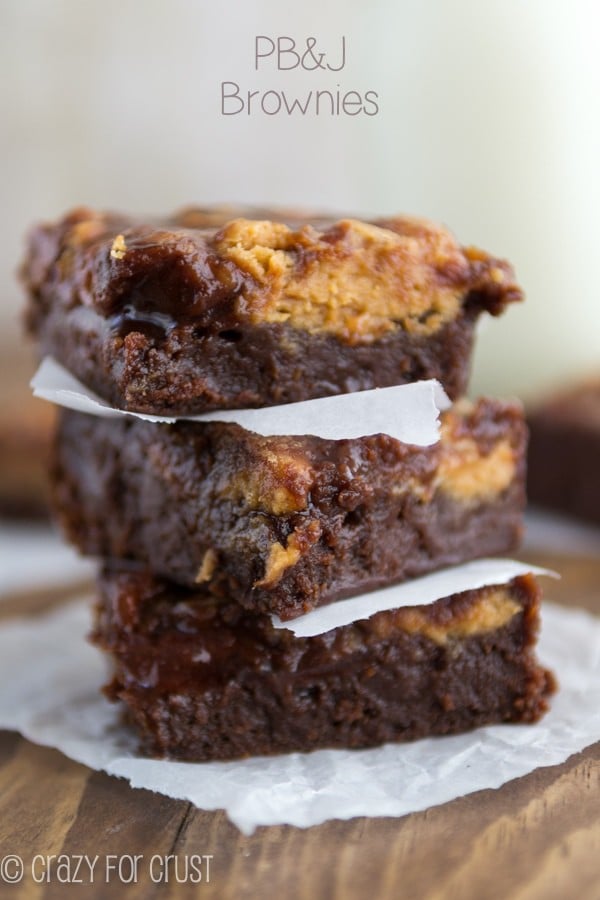 The BEST Peanut Butter and Jelly Brownies stacked on parchment paper