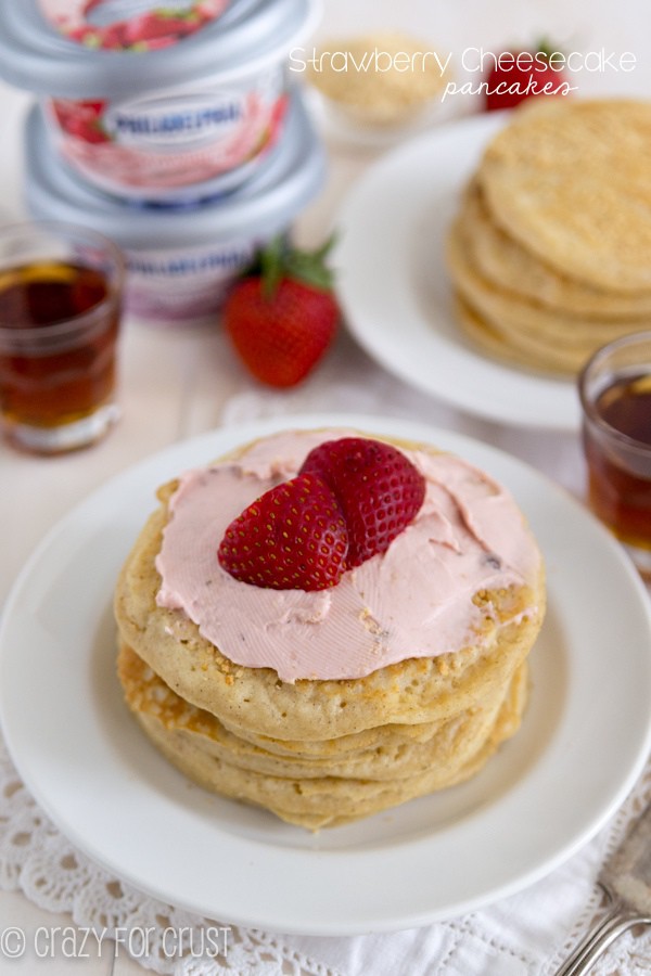 Strawberry Cheesecake Pancakes on a white plate with strawberries on top