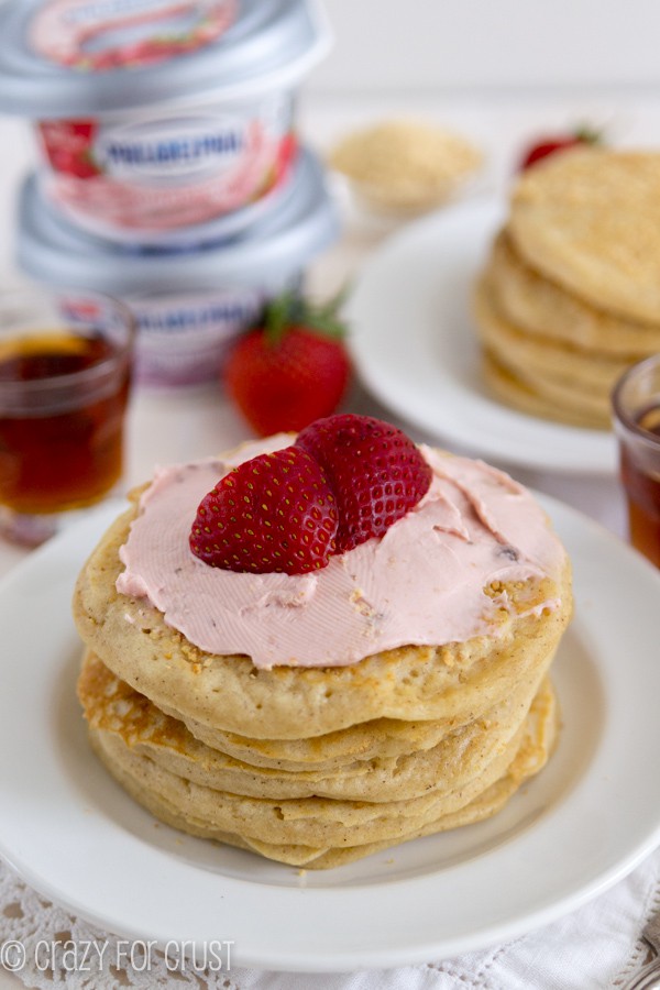 Strawberry Cheesecake Pancakes with strawberries on top on a white plate 