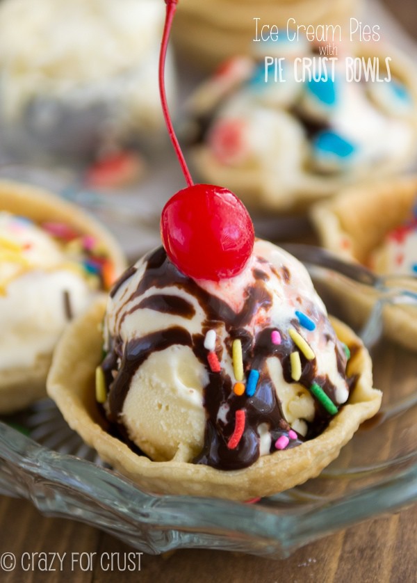 Close up of ice cream scoop in a pie crust bowl with cherry on top
