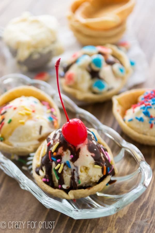 two ice cream pies in a clear bowl on a brown board