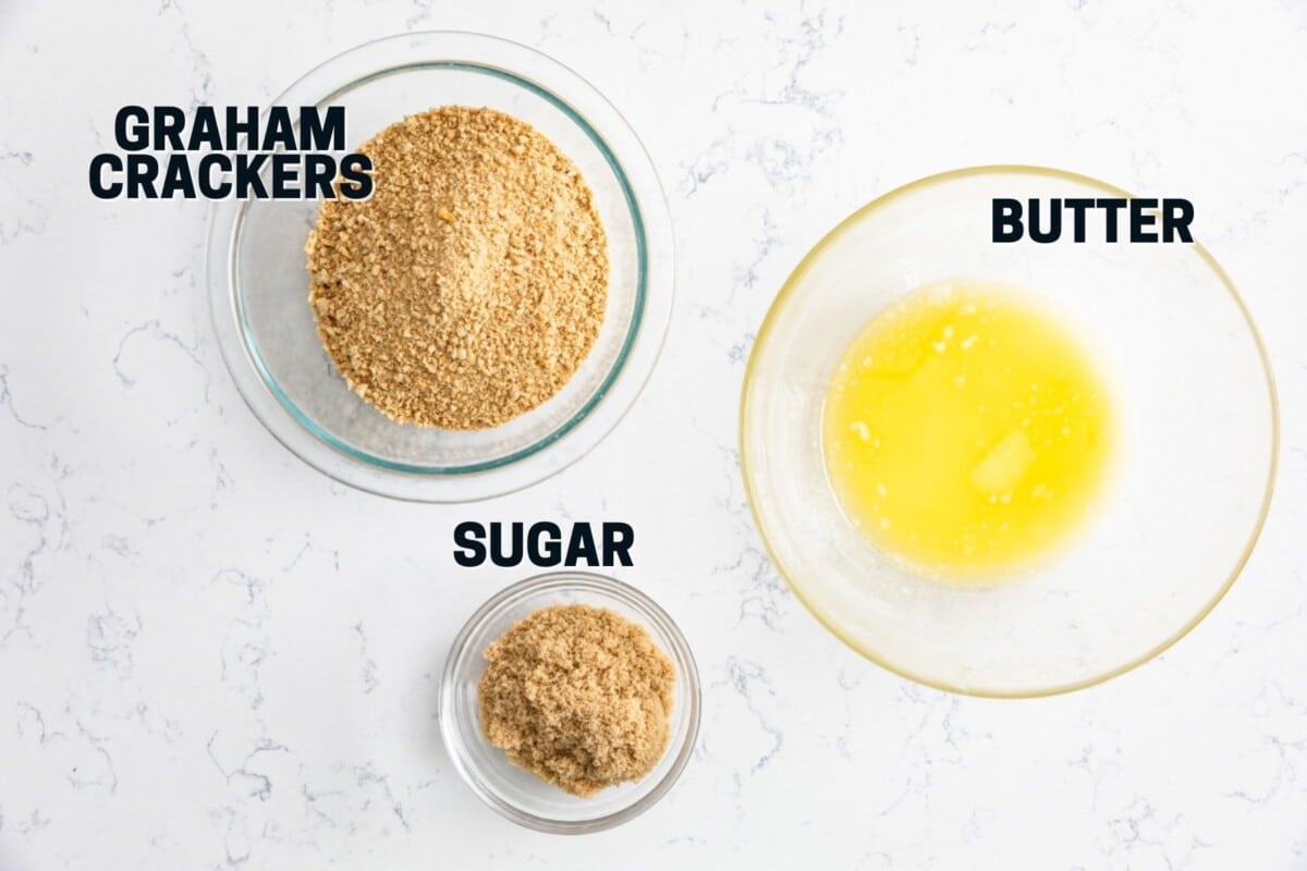ingredients in a graham cracker crust - bowl of graham cracker crumbs, bowl of melted butter and bowl of brown sugar