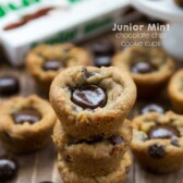 Junior mint chocolate chip cookie cups stacked on top of each other with junior mint box in the background