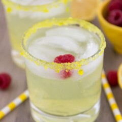 lemon drop fizz in a short clear glass with a raspberry in the drink